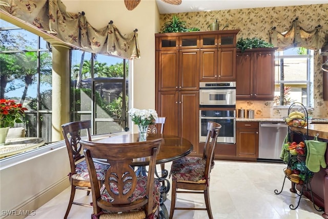 kitchen with light stone countertops, a wealth of natural light, sink, and stainless steel appliances