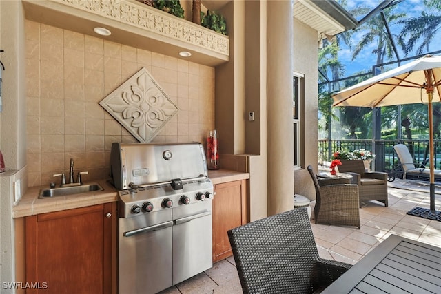 view of patio / terrace featuring area for grilling, glass enclosure, and sink