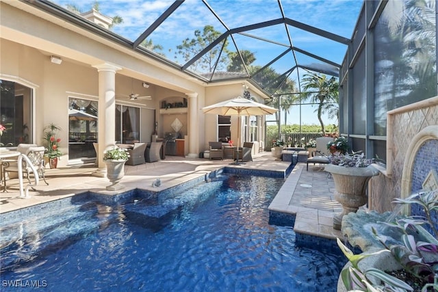 view of pool with outdoor lounge area, ceiling fan, a lanai, and a patio