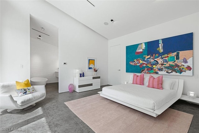bedroom featuring finished concrete flooring and vaulted ceiling