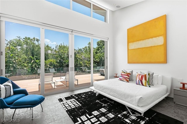 bedroom featuring a high ceiling and access to outside