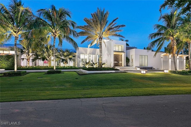 view of front of house featuring stucco siding and a front lawn