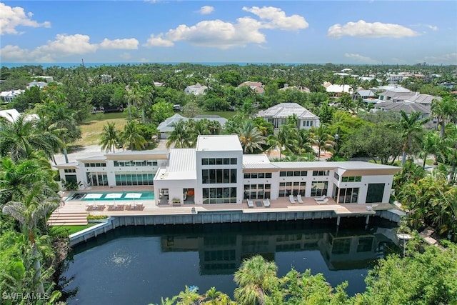 rear view of property featuring a water view and an outdoor pool