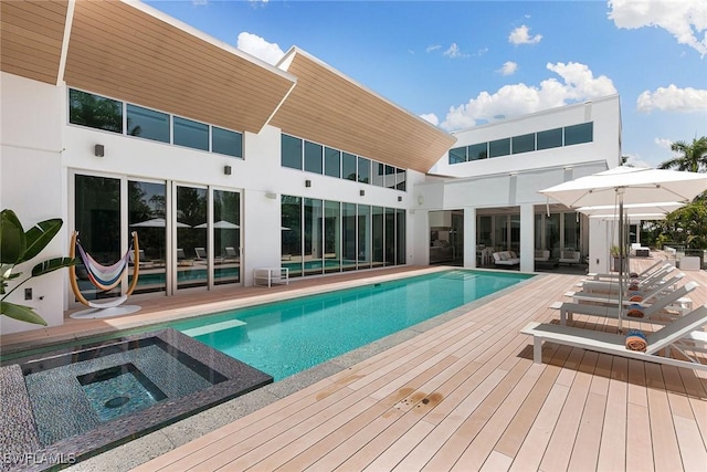 view of swimming pool with a wooden deck and a pool with connected hot tub