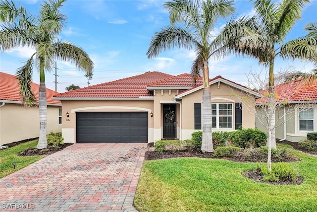 mediterranean / spanish-style house featuring a front lawn and a garage