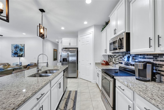 kitchen featuring stainless steel appliances, decorative light fixtures, white cabinets, and sink