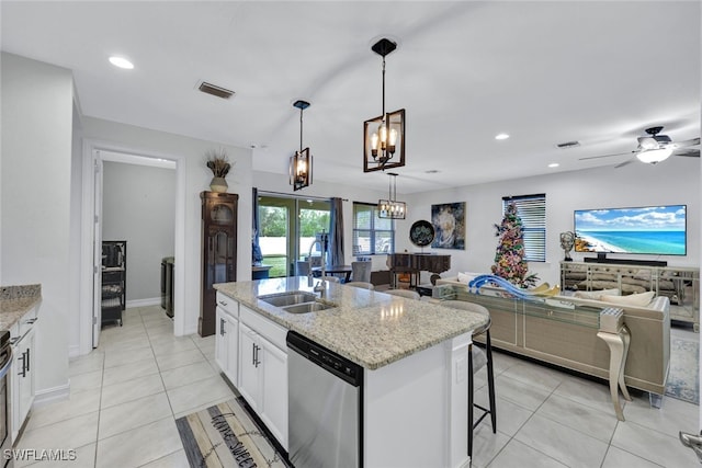 kitchen featuring light stone counters, stainless steel dishwasher, a center island with sink, and white cabinetry