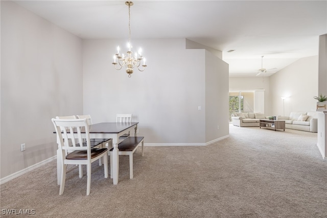 dining area featuring ceiling fan with notable chandelier, light colored carpet, and lofted ceiling