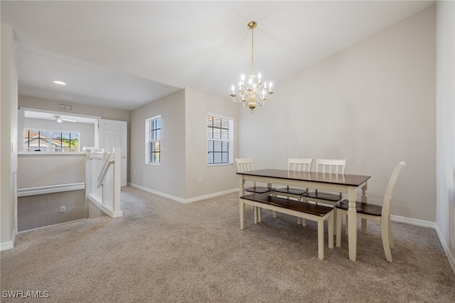 dining space featuring light carpet, plenty of natural light, and ceiling fan with notable chandelier