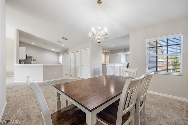 carpeted dining room with vaulted ceiling and an inviting chandelier