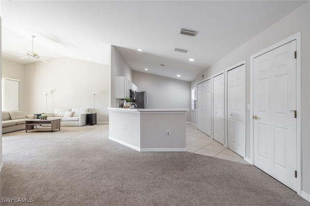 kitchen with ceiling fan, light colored carpet, vaulted ceiling, white cabinets, and appliances with stainless steel finishes