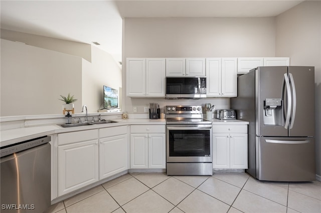 kitchen with white cabinets, appliances with stainless steel finishes, light tile patterned flooring, and sink