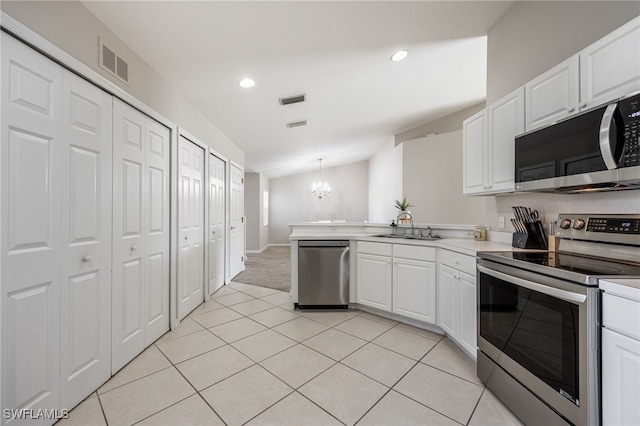 kitchen with white cabinets, appliances with stainless steel finishes, decorative light fixtures, and sink