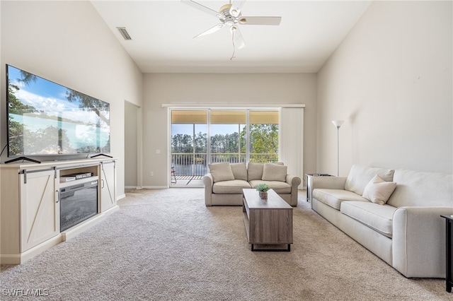 carpeted living room with ceiling fan