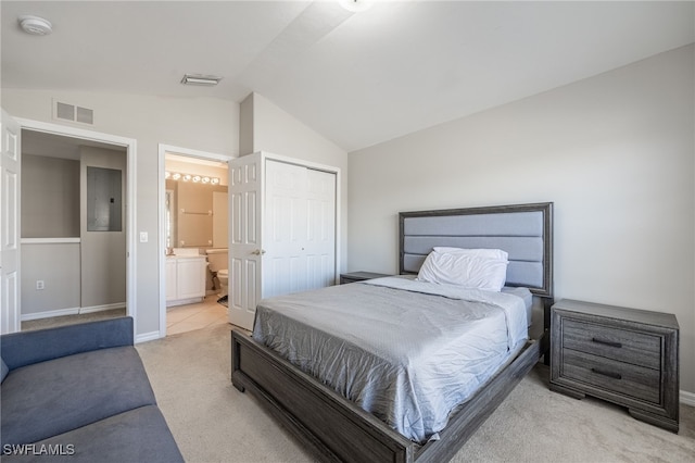 bedroom with lofted ceiling, electric panel, ensuite bathroom, light colored carpet, and a closet