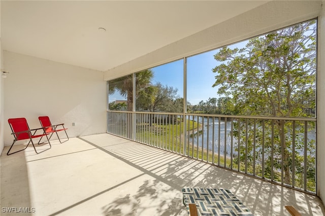 unfurnished sunroom featuring a water view