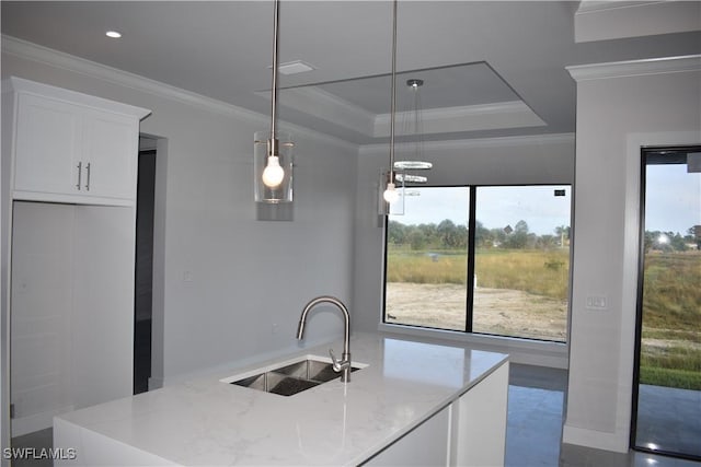 kitchen with pendant lighting, a raised ceiling, sink, light stone countertops, and white cabinetry