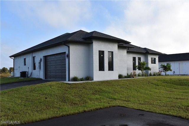 view of side of home with a yard, cooling unit, and a garage