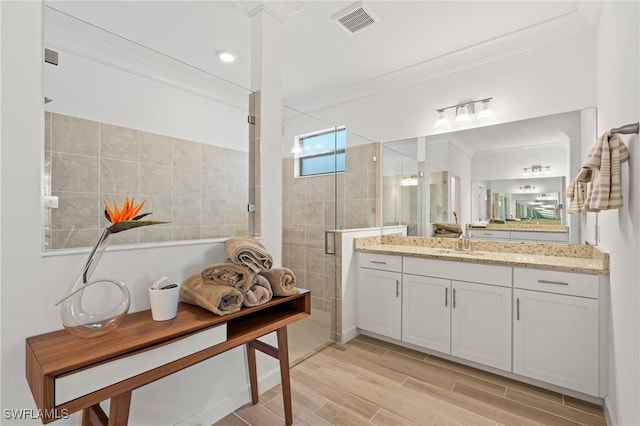 bathroom featuring vanity, an enclosed shower, and ornamental molding