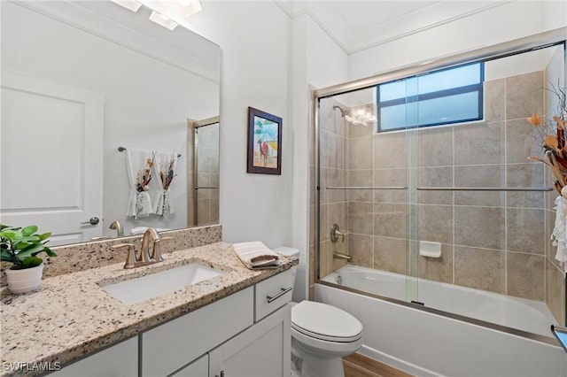 full bathroom with enclosed tub / shower combo, hardwood / wood-style floors, toilet, vanity, and ornamental molding