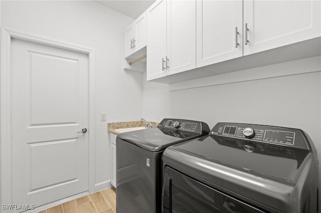 laundry area featuring sink, cabinets, and independent washer and dryer