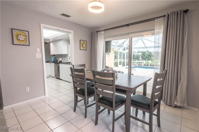 tiled dining area with a textured ceiling