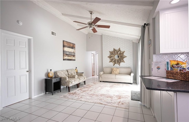 living room featuring light tile patterned floors, lofted ceiling with beams, a textured ceiling, and ceiling fan