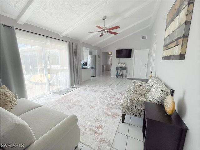 tiled living room with ceiling fan, lofted ceiling with beams, and a textured ceiling