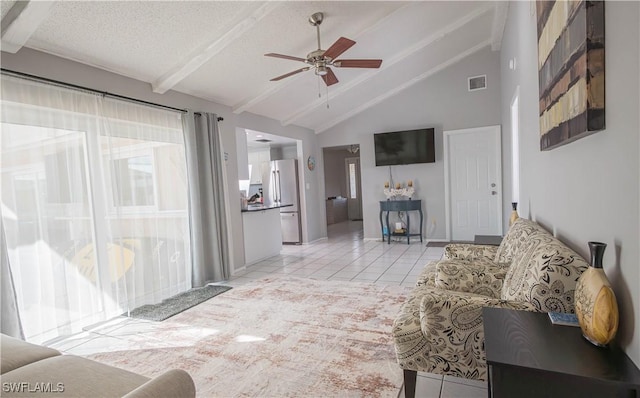 tiled living room featuring a textured ceiling, lofted ceiling with beams, and ceiling fan