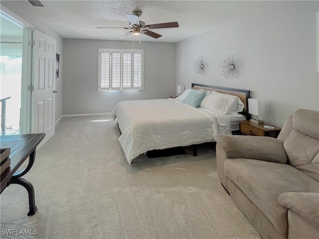 bedroom with ceiling fan, a textured ceiling, and light carpet