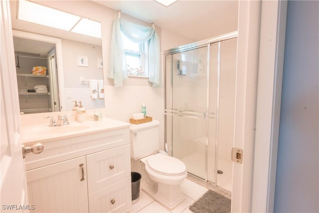 bathroom featuring tile patterned floors, vanity, toilet, and a shower with shower door