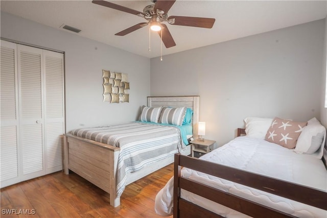 bedroom with ceiling fan, a closet, and dark hardwood / wood-style floors