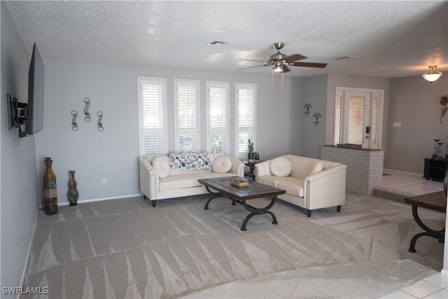 living room with ceiling fan, light carpet, and a textured ceiling