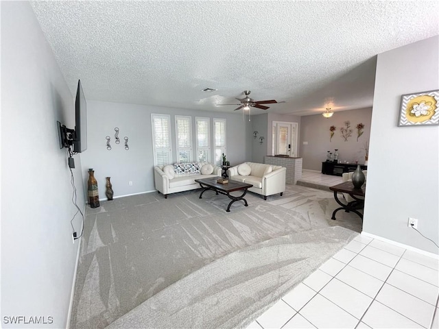 tiled living room featuring ceiling fan and a textured ceiling