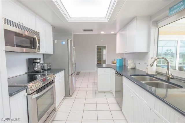 kitchen featuring ornamental molding, stainless steel appliances, sink, white cabinets, and light tile patterned flooring