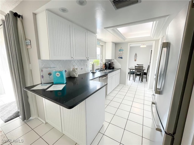 kitchen with white cabinetry, sink, tasteful backsplash, light tile patterned flooring, and appliances with stainless steel finishes