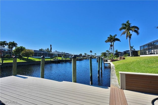 dock area with a lawn and a water view