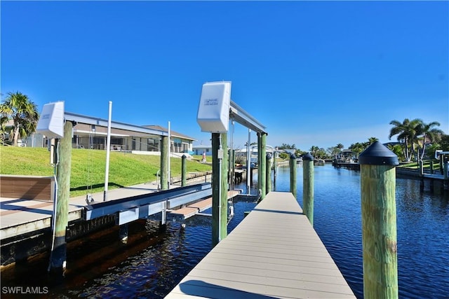 dock area with a water view and a yard