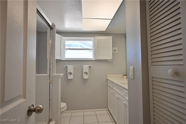 bathroom with toilet, vanity, and tile patterned floors