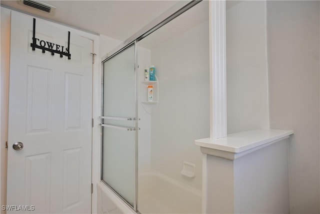 bathroom with shower / bath combination with glass door