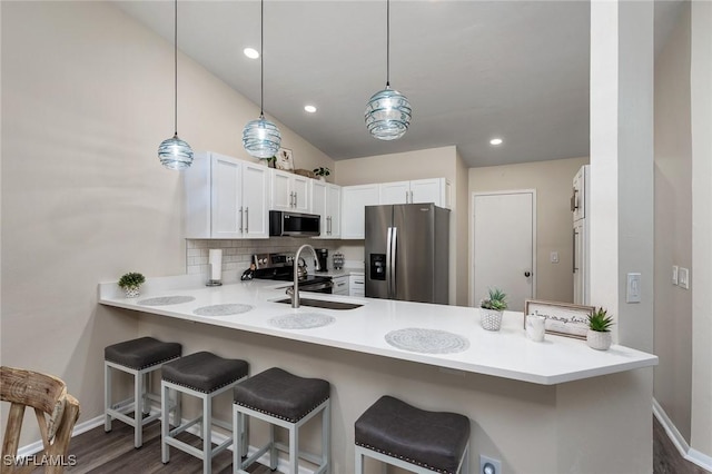 kitchen featuring kitchen peninsula, hanging light fixtures, and appliances with stainless steel finishes