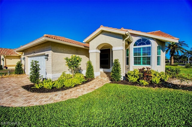 mediterranean / spanish home with a front yard and a garage