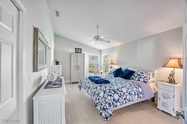 bedroom with light hardwood / wood-style flooring, vaulted ceiling, and ceiling fan