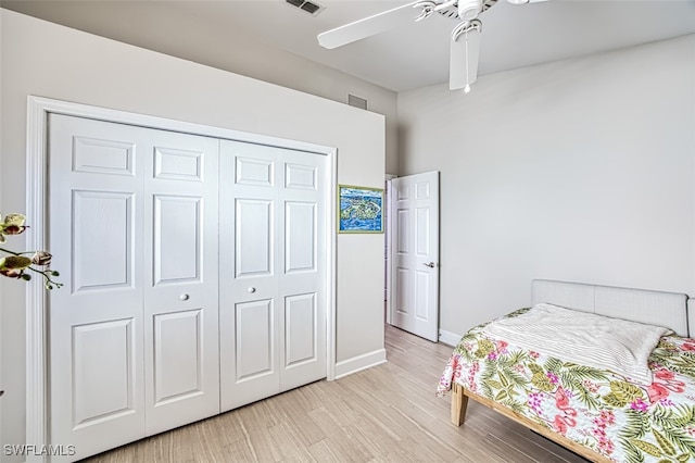 bedroom with ceiling fan, light hardwood / wood-style flooring, and a closet