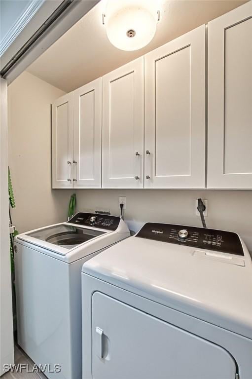 laundry area featuring washing machine and clothes dryer and cabinets