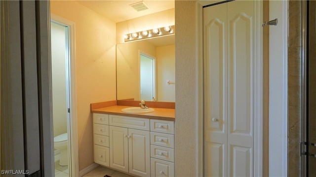 bathroom featuring tile patterned flooring, vanity, and toilet