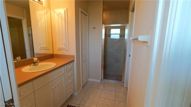 bathroom with tile patterned flooring, vanity, and a shower with door