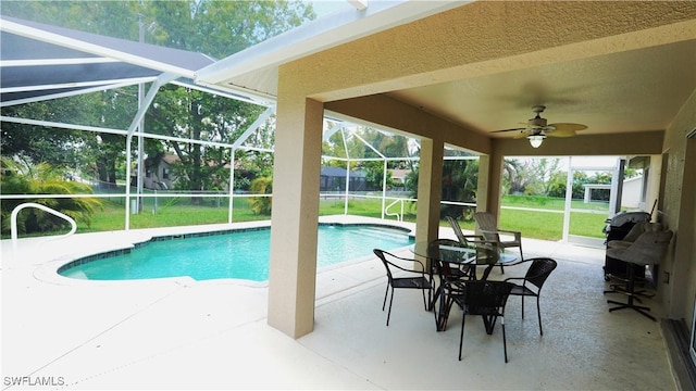 view of pool featuring a lawn, ceiling fan, a lanai, and a patio