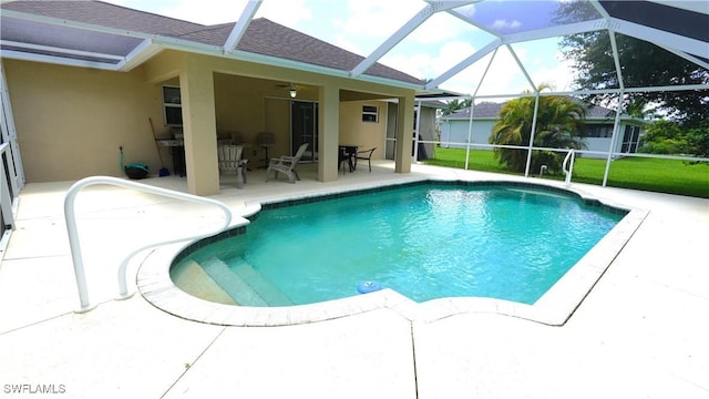 view of swimming pool featuring glass enclosure, ceiling fan, and a patio