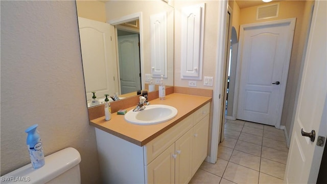 bathroom featuring tile patterned flooring, vanity, and toilet